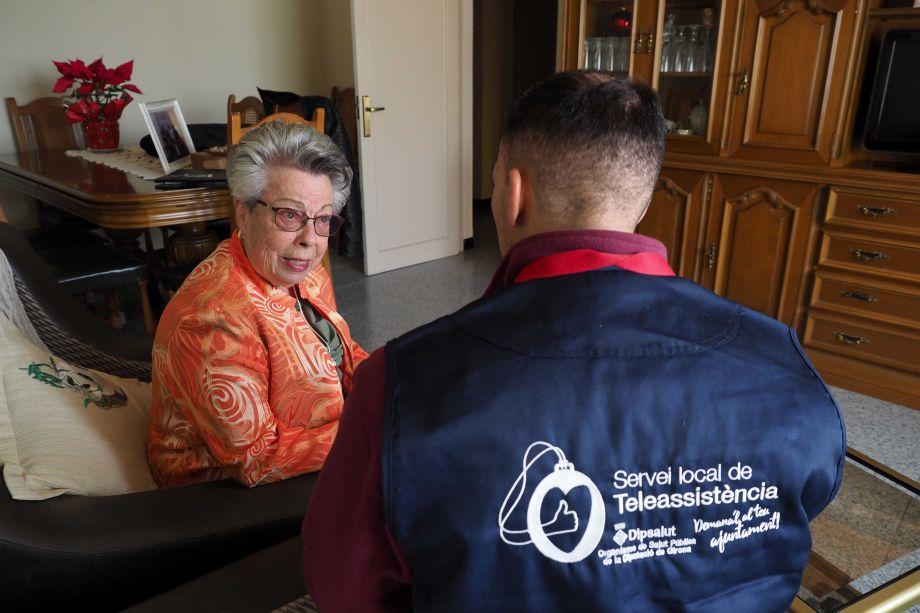 Un treballador del servei realitzant visita de seguiment a una usuària, al seu domicili, a Sarrià de Ter.
